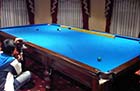 Trained movers ensuring the safe transportation of a pool table during relocation